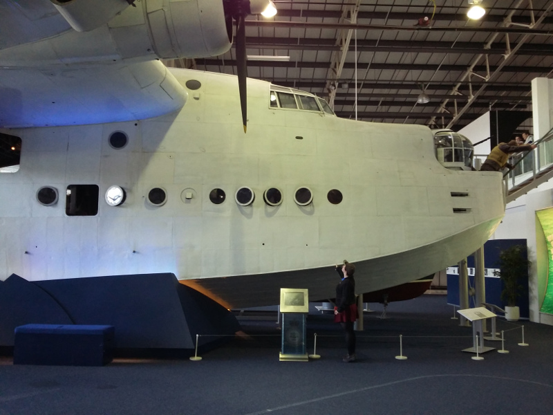 Side view of the Sunderland flying boat's forward section, taken from ground level. Stood next to the aircraft, Sandra is able to reach the seam where the sides meet the base of the hull