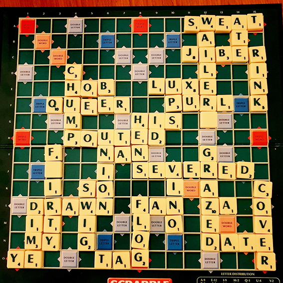 Photo of a Scrabble board part-way through a game, showing a wide variety of words in play.